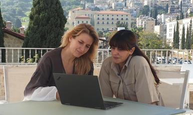 Chaya en Jetske van den Elzen kijken samen op een laptop